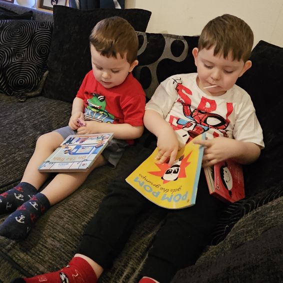 Two young boys reading books