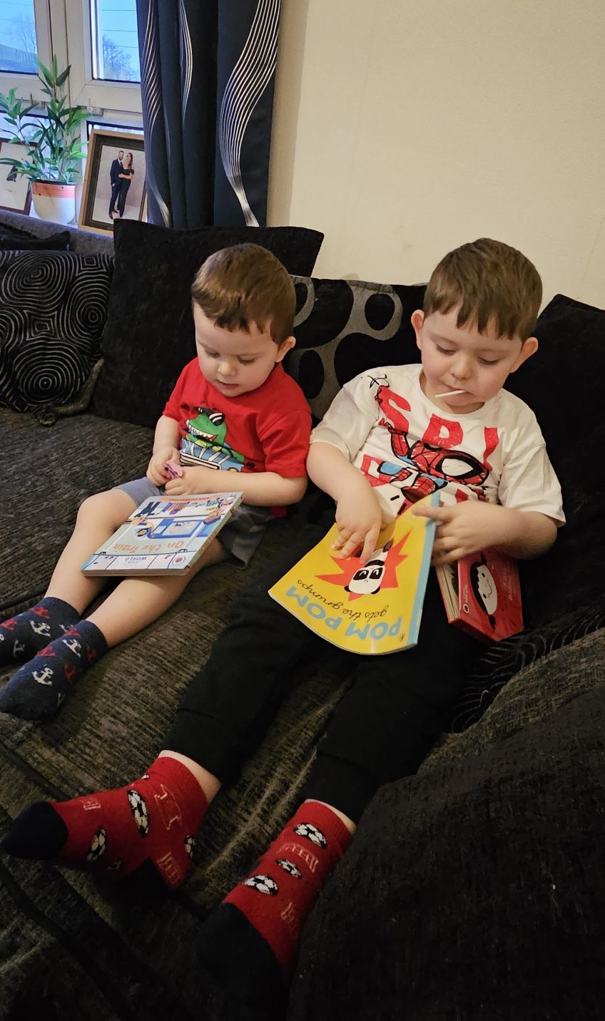 Two young boys reading books