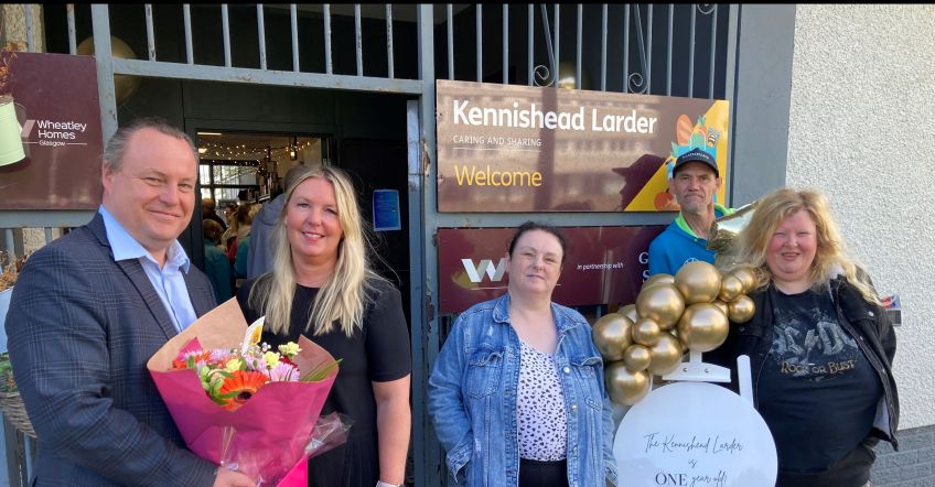 Chris Stephens MP, Kennishead Larder Co-ordinator Suzanne Oliver and tenants standing outside in front of Kennishead Larder